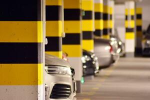 Departure from the underground garage with white gate. Interior pillars painted yellow. photo