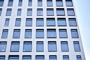 Modern office building in the city with windows and  steel and aluminum panels wall. Contemporary commercial architecture, vertical converging geometric lines. photo