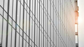 Glass modern building with blue sky background. View and architecture details. Urban abstract - windows of glass office building in  sunlight day. Black and white. photo