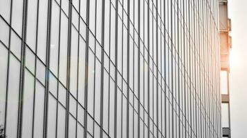 Glass modern building with blue sky background. View and architecture details. Urban abstract - windows of glass office building in  sunlight day. Black and white. photo