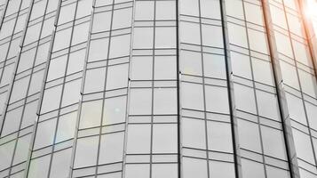 Glass modern building with blue sky background. View and architecture details. Urban abstract - windows of glass office building in  sunlight day. Black and white. photo