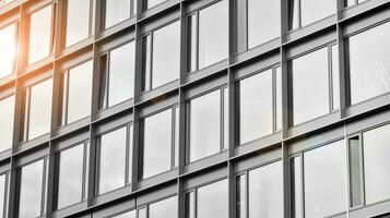 Glass modern building with blue sky background. View and architecture details. Urban abstract - windows of glass office building in  sunlight day. Black and white. photo