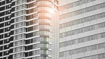 Glass modern building with blue sky background. View and architecture details. Urban abstract - windows of glass office building in  sunlight day. Black and white. photo