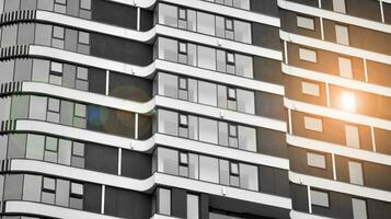 Glass modern building with blue sky background. View and architecture details. Urban abstract - windows of glass office building in  sunlight day. Black and white. photo