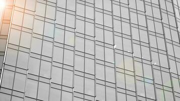 Glass modern building with blue sky background. View and architecture details. Urban abstract - windows of glass office building in  sunlight day. Black and white. photo