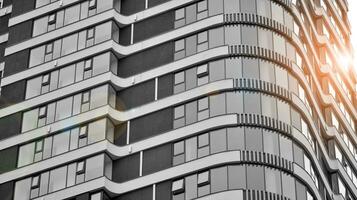 Glass modern building with blue sky background. View and architecture details. Urban abstract - windows of glass office building in  sunlight day. Black and white. photo