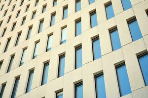 Modern office building detail. Perspective view of geometric angular concrete windows on the facade of a modernist brutalist style building. photo