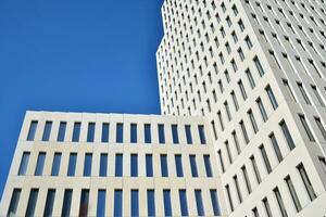 Modern office building detail. Perspective view of geometric angular concrete windows on the facade of a modernist brutalist style building. photo