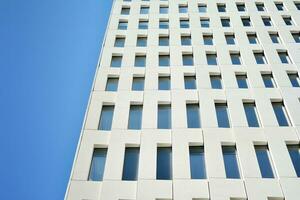 Modern office building detail. Perspective view of geometric angular concrete windows on the facade of a modernist brutalist style building. photo