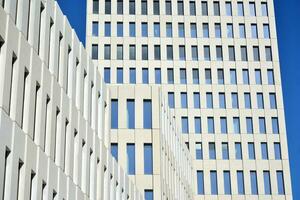 Modern office building detail. Perspective view of geometric angular concrete windows on the facade of a modernist brutalist style building. photo