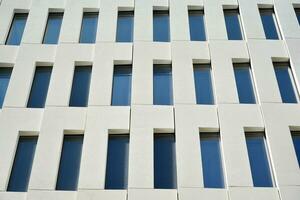 Modern office building detail. Perspective view of geometric angular concrete windows on the facade of a modernist brutalist style building. photo