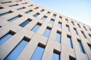 Modern office building detail. Perspective view of geometric angular concrete windows on the facade of a modernist brutalist style building. photo