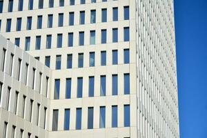 Modern office building detail. Perspective view of geometric angular concrete windows on the facade of a modernist brutalist style building. photo