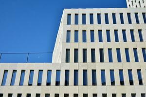 Modern office building detail. Perspective view of geometric angular concrete windows on the facade of a modernist brutalist style building. photo