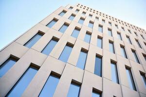 Modern office building detail. Perspective view of geometric angular concrete windows on the facade of a modernist brutalist style building. photo