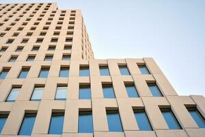 Modern office building detail. Perspective view of geometric angular concrete windows on the facade of a modernist brutalist style building. photo