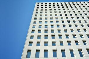 Modern office building detail. Perspective view of geometric angular concrete windows on the facade of a modernist brutalist style building. photo