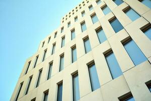 Modern office building detail. Perspective view of geometric angular concrete windows on the facade of a modernist brutalist style building. photo