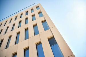 Modern office building detail. Perspective view of geometric angular concrete windows on the facade of a modernist brutalist style building. photo