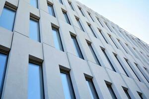 Modern office building detail. Perspective view of geometric angular concrete windows on the facade of a modernist brutalist style building. photo
