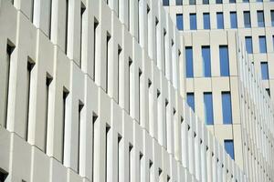 Modern office building detail. Perspective view of geometric angular concrete windows on the facade of a modernist brutalist style building. photo