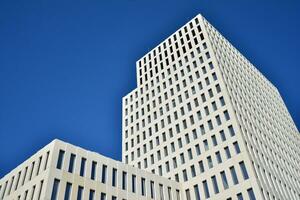 Modern office building detail. Perspective view of geometric angular concrete windows on the facade of a modernist brutalist style building. photo