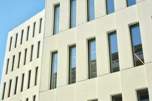 Modern office building detail. Perspective view of geometric angular concrete windows on the facade of a modernist brutalist style building. photo
