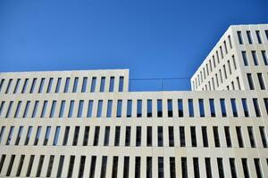 Modern office building detail. Perspective view of geometric angular concrete windows on the facade of a modernist brutalist style building. photo