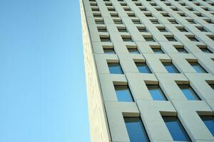 Modern office building detail. Perspective view of geometric angular concrete windows on the facade of a modernist brutalist style building. photo