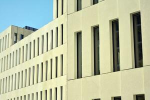 Modern office building detail. Perspective view of geometric angular concrete windows on the facade of a modernist brutalist style building. photo