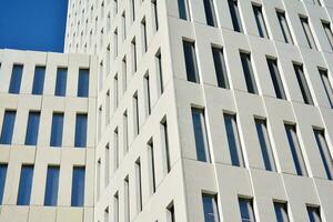 Modern office building detail. Perspective view of geometric angular concrete windows on the facade of a modernist brutalist style building. photo