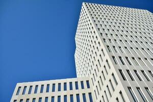 Modern office building detail. Perspective view of geometric angular concrete windows on the facade of a modernist brutalist style building. photo