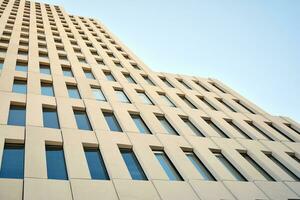 Modern office building detail. Perspective view of geometric angular concrete windows on the facade of a modernist brutalist style building. photo