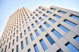 Modern office building detail. Perspective view of geometric angular concrete windows on the facade of a modernist brutalist style building. photo