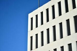 Modern office building detail. Perspective view of geometric angular concrete windows on the facade of a modernist brutalist style building. photo