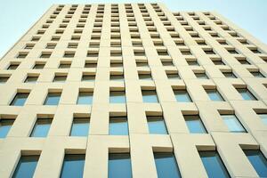 Modern office building detail. Perspective view of geometric angular concrete windows on the facade of a modernist brutalist style building. photo
