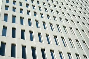 Modern office building detail. Perspective view of geometric angular concrete windows on the facade of a modernist brutalist style building. photo