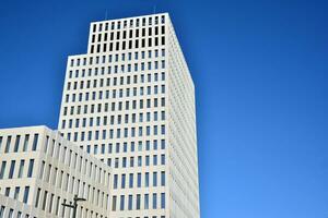 Modern office building detail. Perspective view of geometric angular concrete windows on the facade of a modernist brutalist style building. photo