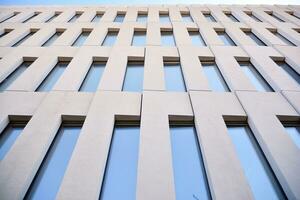 Modern office building detail. Perspective view of geometric angular concrete windows on the facade of a modernist brutalist style building. photo