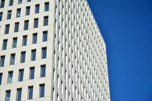 Modern office building detail. Perspective view of geometric angular concrete windows on the facade of a modernist brutalist style building. photo