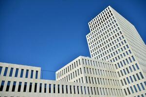 Modern office building detail. Perspective view of geometric angular concrete windows on the facade of a modernist brutalist style building. photo