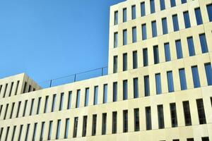 Modern office building detail. Perspective view of geometric angular concrete windows on the facade of a modernist brutalist style building. photo