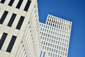 Modern office building detail. Perspective view of geometric angular concrete windows on the facade of a modernist brutalist style building. photo