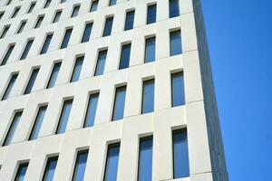 Modern office building detail. Perspective view of geometric angular concrete windows on the facade of a modernist brutalist style building. photo