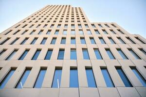 Modern office building detail. Perspective view of geometric angular concrete windows on the facade of a modernist brutalist style building. photo