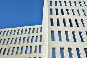 Modern office building detail. Perspective view of geometric angular concrete windows on the facade of a modernist brutalist style building. photo