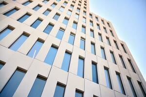 Modern office building detail. Perspective view of geometric angular concrete windows on the facade of a modernist brutalist style building. photo
