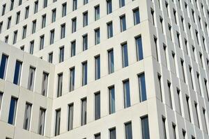 Modern office building detail. Perspective view of geometric angular concrete windows on the facade of a modernist brutalist style building. photo