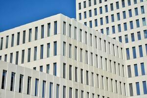 Modern office building detail. Perspective view of geometric angular concrete windows on the facade of a modernist brutalist style building. photo