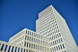 Modern office building detail. Perspective view of geometric angular concrete windows on the facade of a modernist brutalist style building. photo